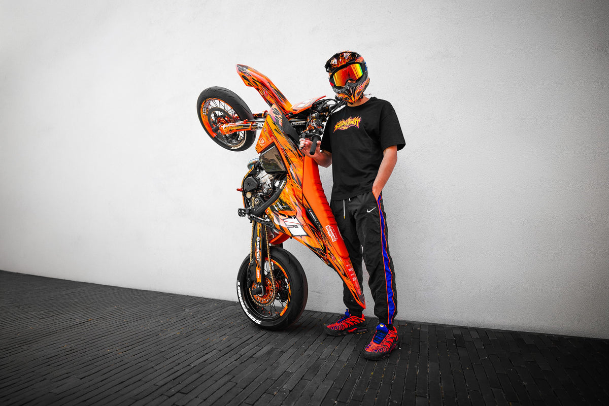 Rider SUPERMOT en wheeling avec sa KTM au kit déco orange Hot Wheels